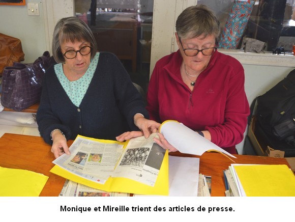 Monique et Mireille trient des articles de presse.
