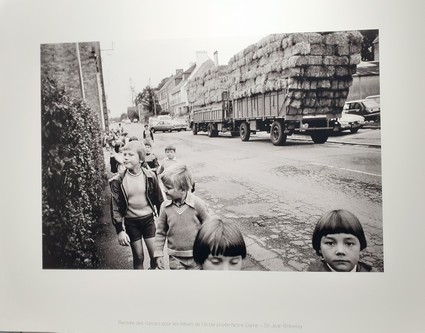 A Saint Jean Brévelay, sortie d'école et traversée du bourg par de grandes remorques de bottes de paille.